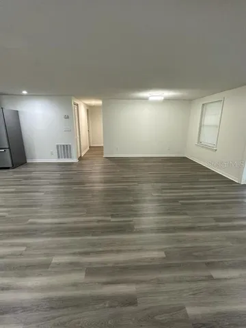 a view of a room with an empty space and window