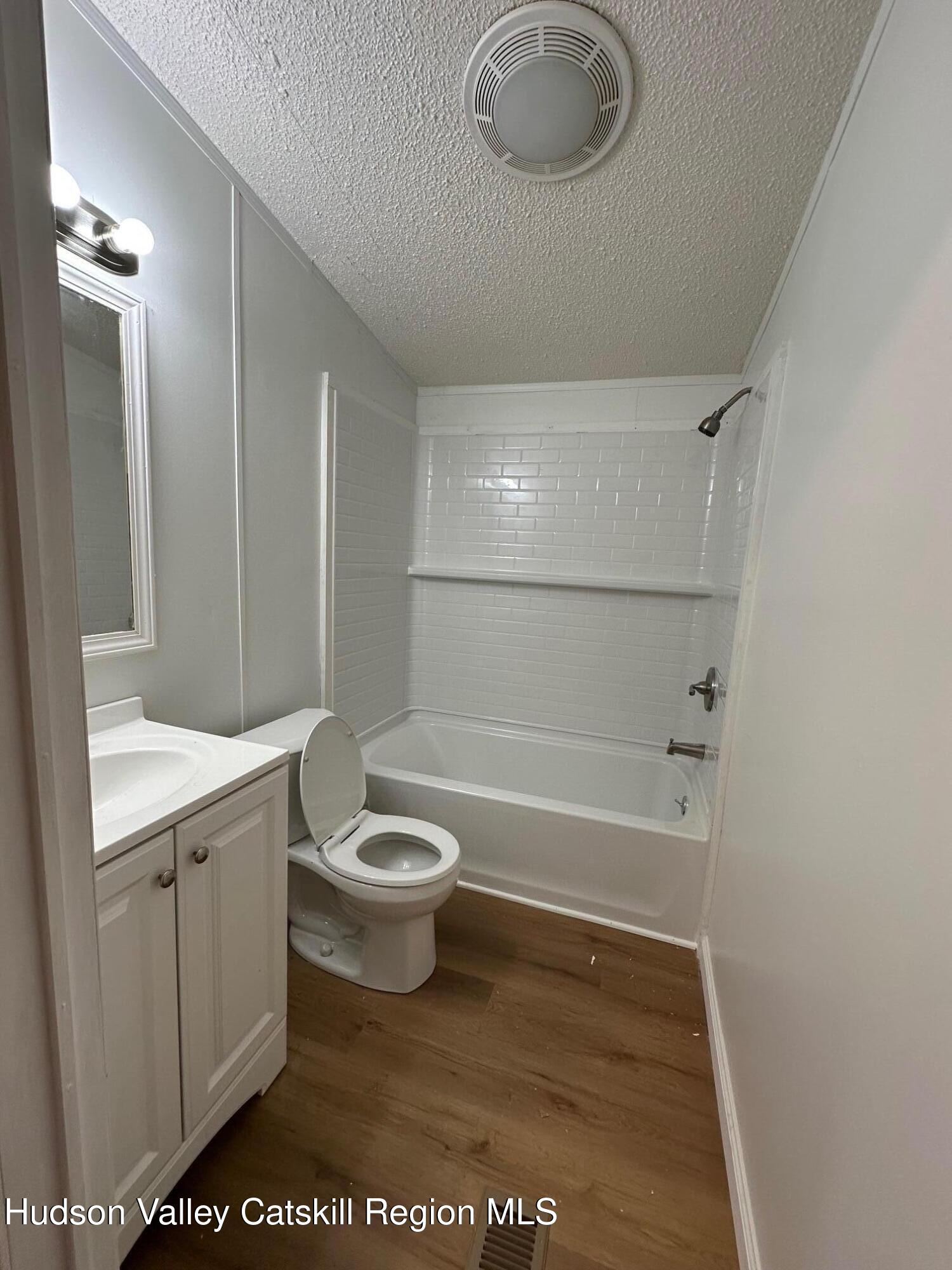 2699 Highway 22, Unit 2 Patterson, NY 12563 - Photo 7 of 11 a bathroom with a toilet a sink a mirror and bathtub
