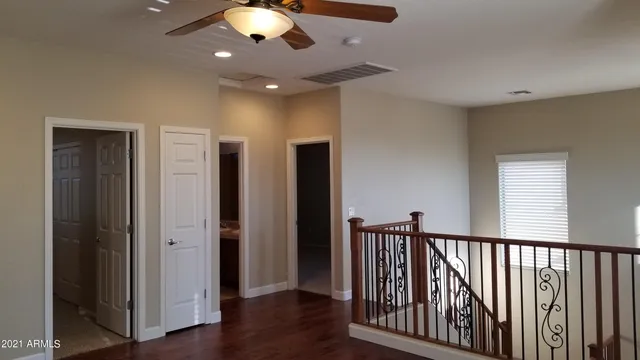 a view of a hallway with wooden floor and staircase