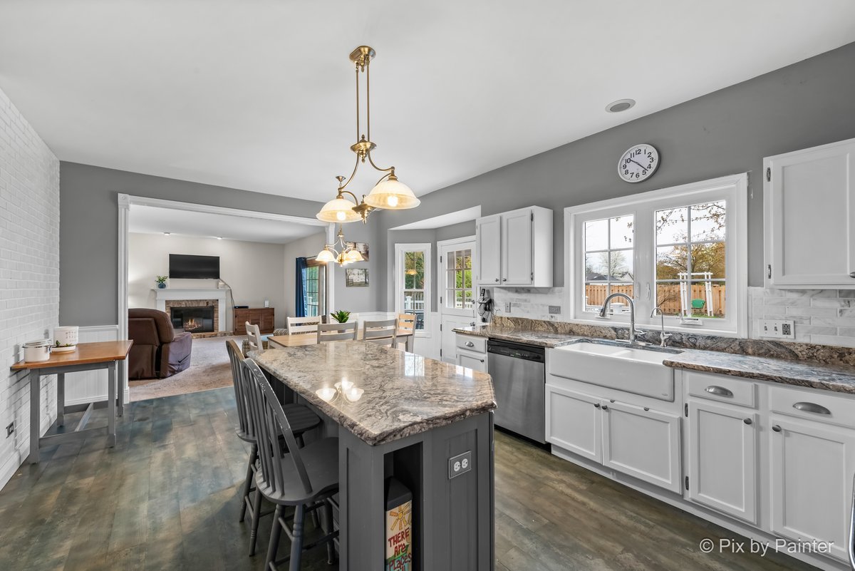 249 Adare Drive Cary, IL 60013 - Photo 15 of 36 a large kitchen with granite countertop lots of counter space dining table and stainless steel appliances