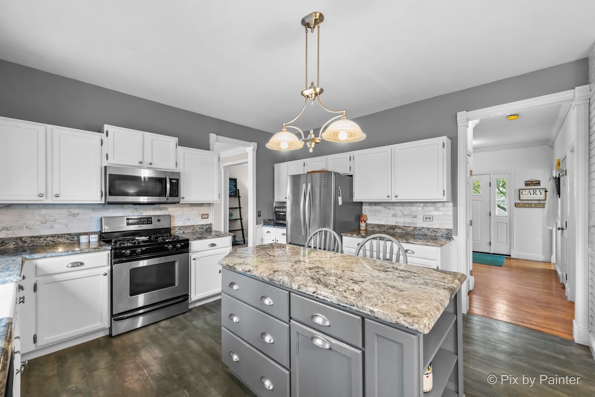 249 Adare Drive Cary, IL 60013 - Photo 17 of 36 a kitchen with kitchen island granite countertop a stove a sink a center island and cabinets