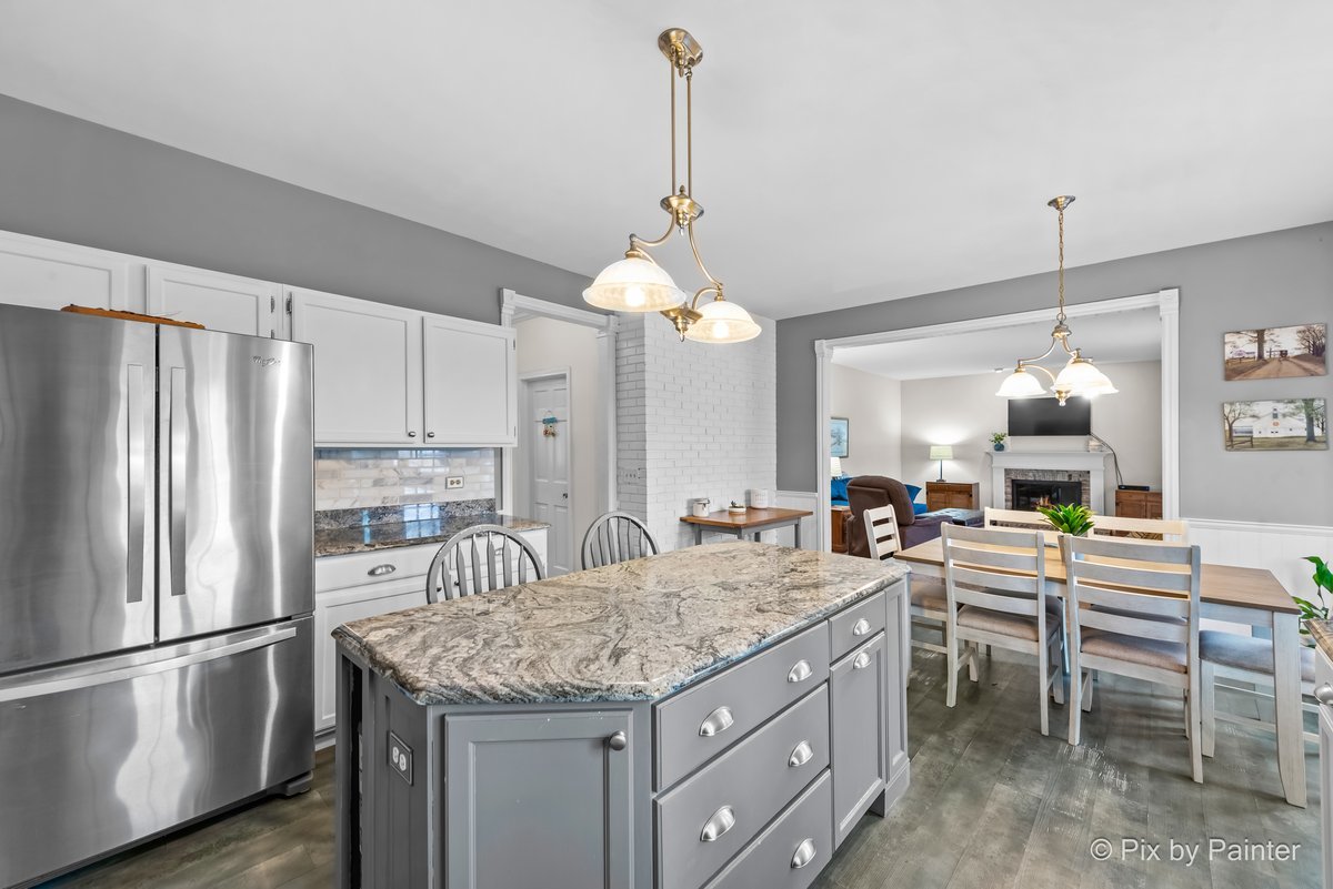 249 Adare Drive Cary, IL 60013 - Photo 18 of 36 a kitchen with a refrigerator a sink and chairs