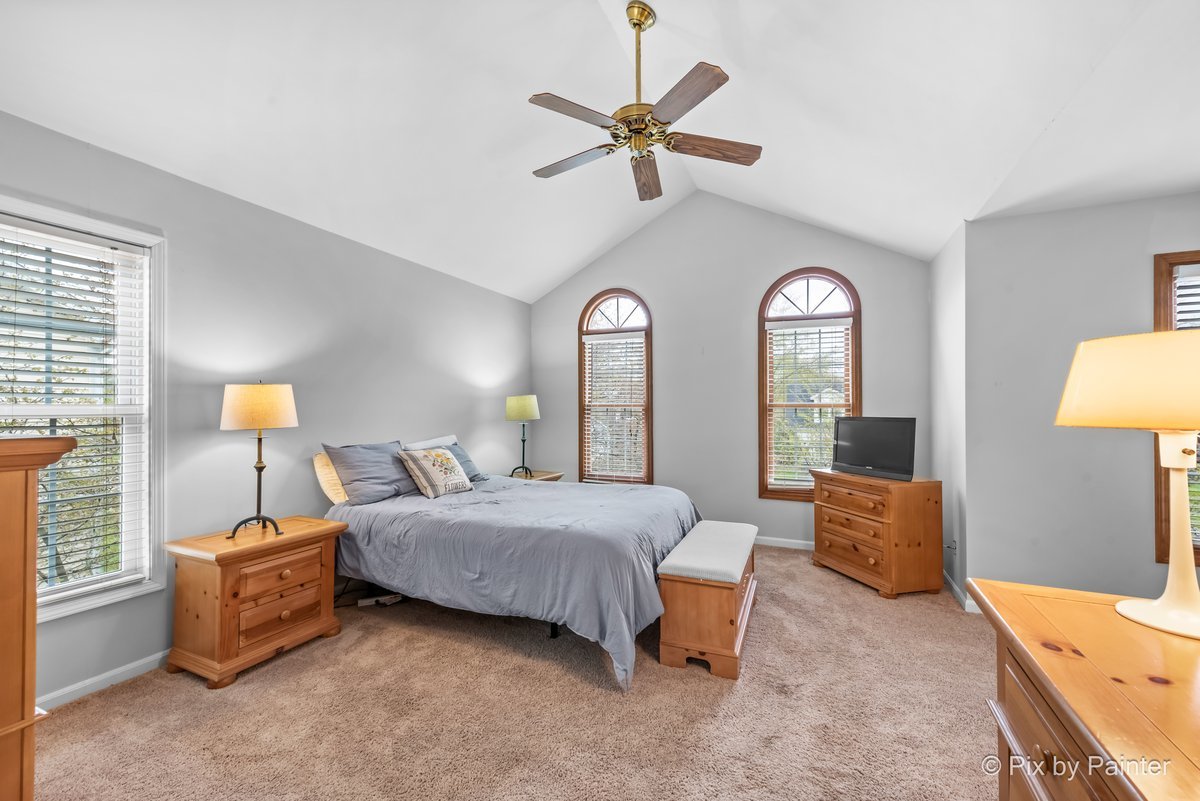 249 Adare Drive Cary, IL 60013 - Photo 25 of 36 a bedroom with a bed and a chandelier