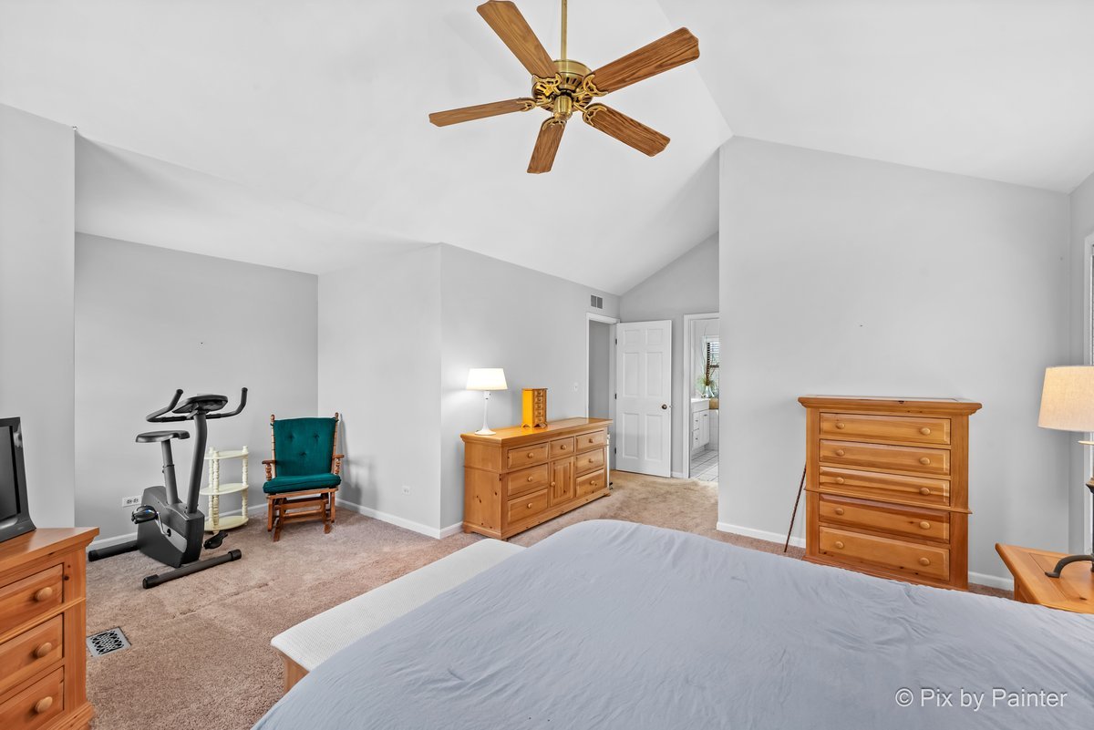 249 Adare Drive Cary, IL 60013 - Photo 26 of 36 a bedroom with a bed and a chandelier