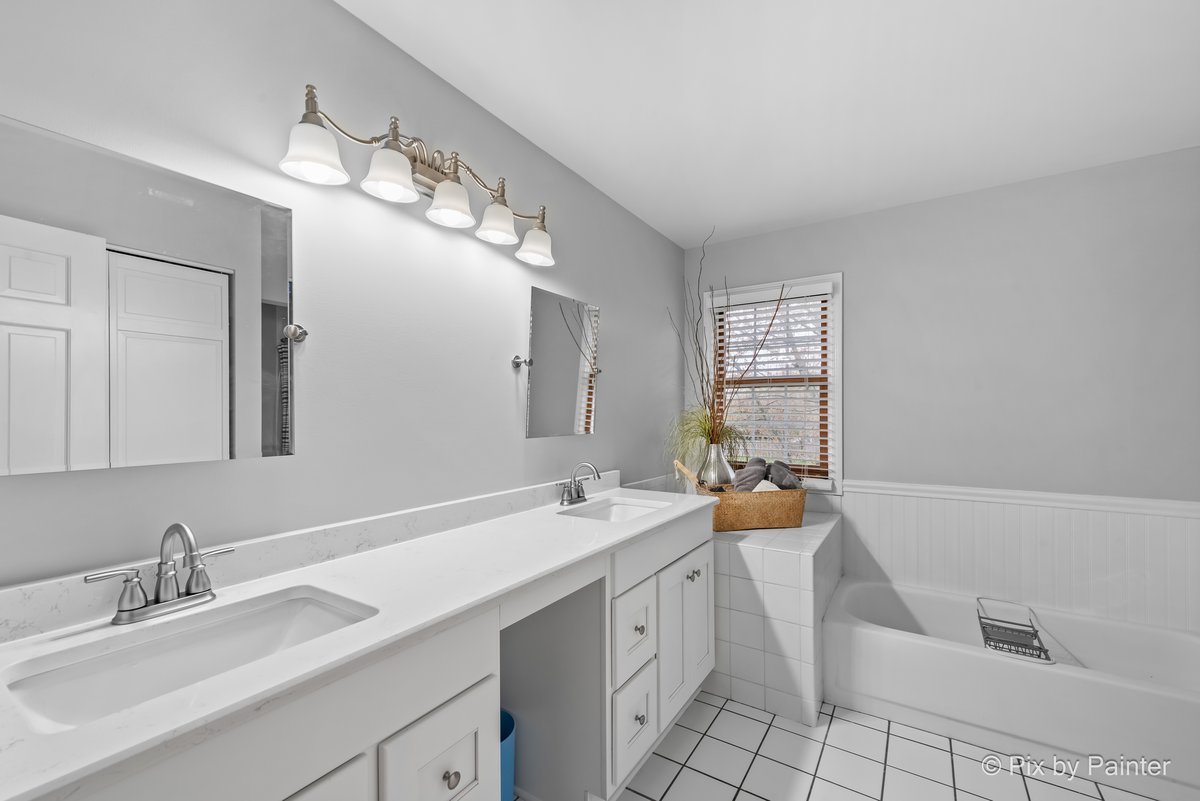 249 Adare Drive Cary, IL 60013 - Photo 27 of 36 a bathroom with a sink a large mirror and a bathtub