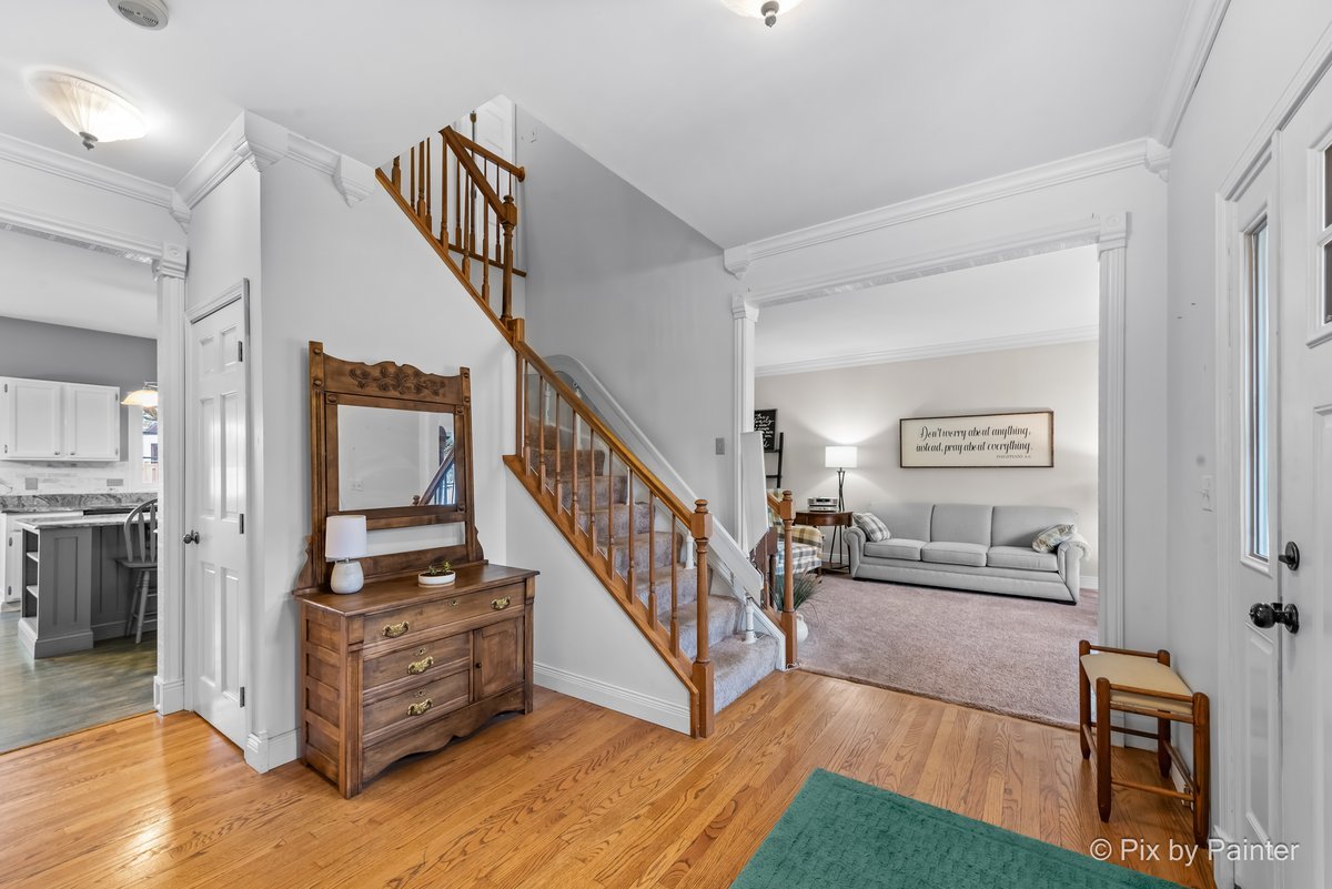 249 Adare Drive Cary, IL 60013 - Photo 8 of 36 a view of a hallway with wooden floor and staircase