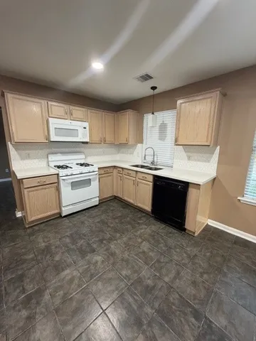 a kitchen with a sink window and cabinets