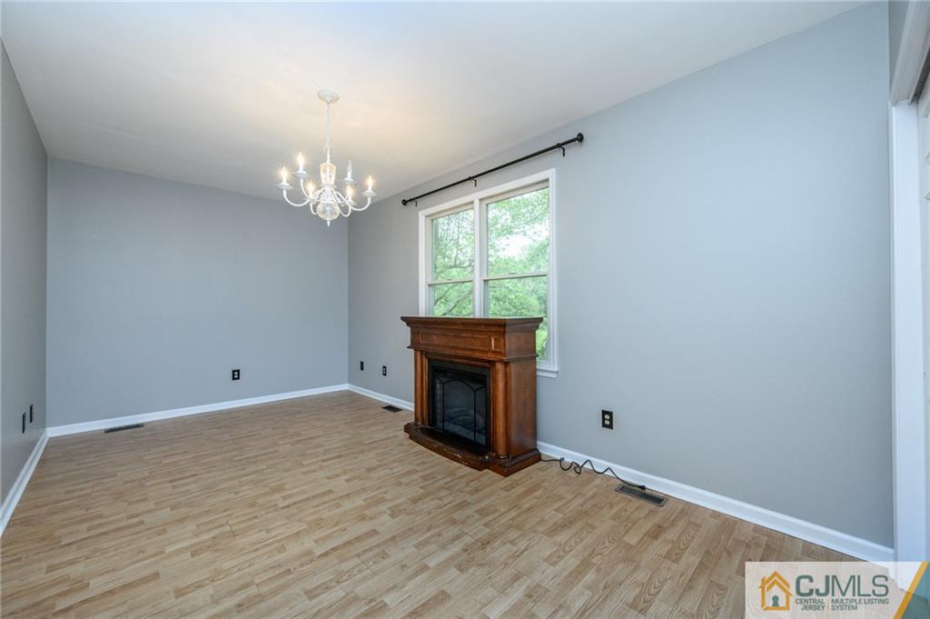 9 Pebble Beach Way Washington, NJ 07882 - Photo 18 of 42 a view of an empty room with wooden floor fireplace and a window