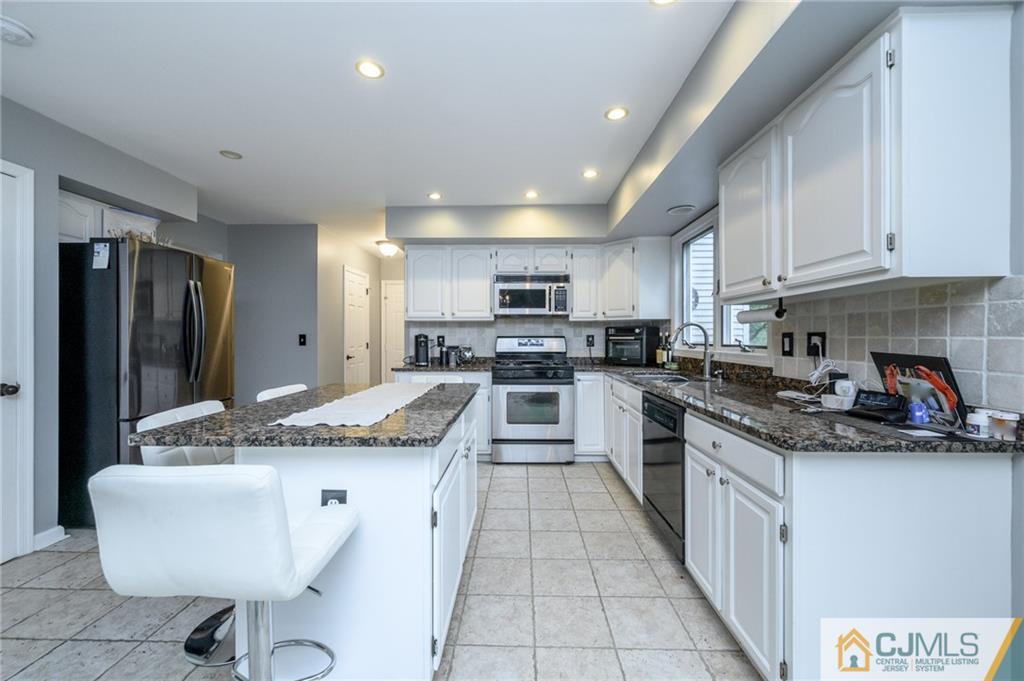 9 Pebble Beach Way Washington, NJ 07882 - Photo 10 of 42 a kitchen with stainless steel appliances granite countertop a sink and cabinets