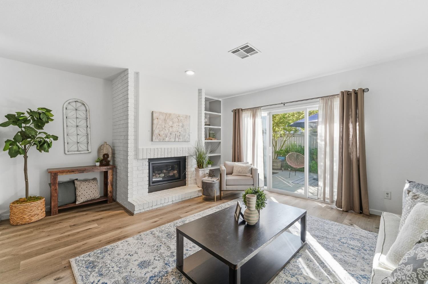 230 West Rumble Road, Unit C Modesto, CA 95350 - Photo 26 of 54 a living room with furniture a fireplace and a potted plant