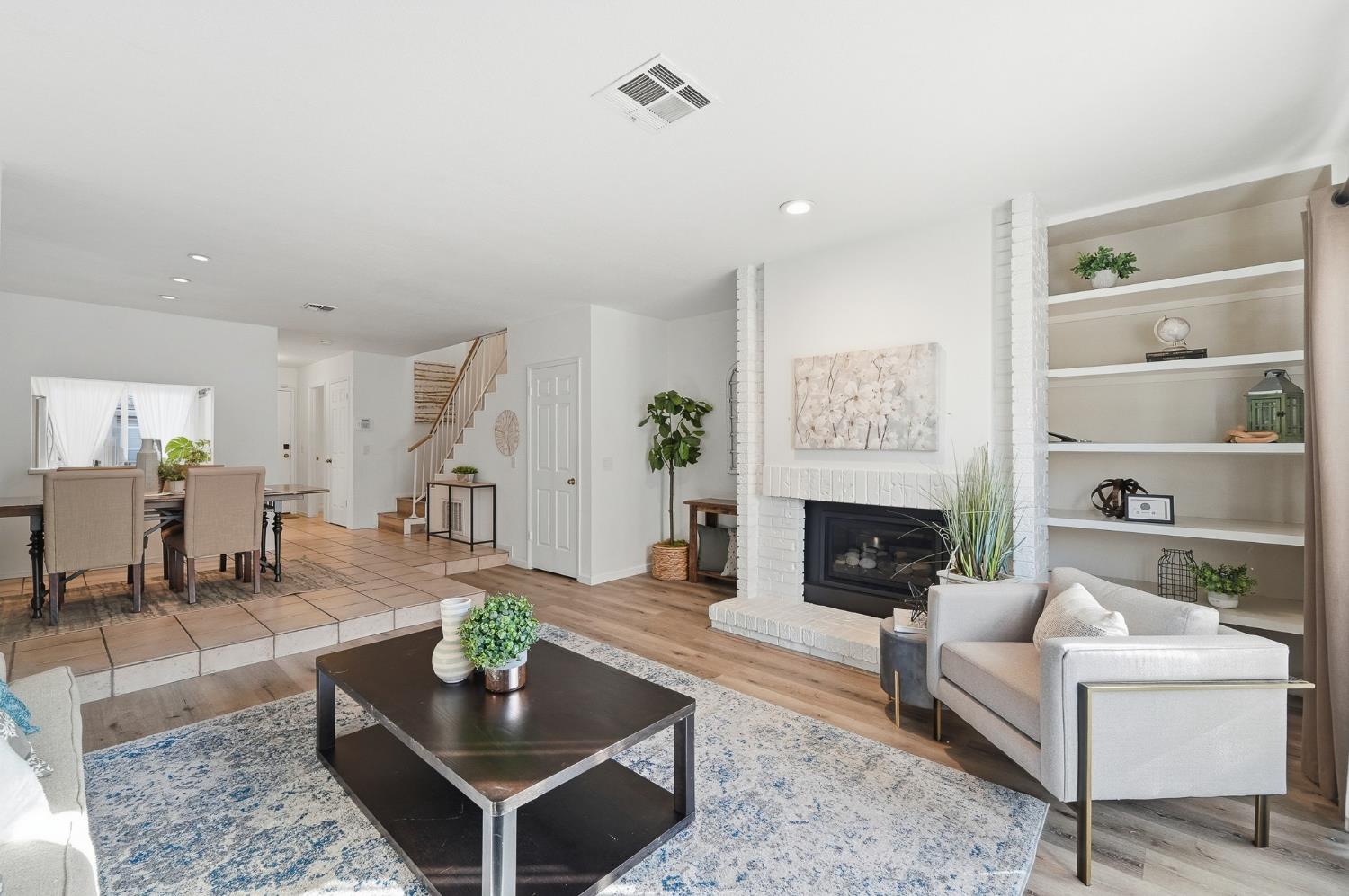 230 West Rumble Road, Unit C Modesto, CA 95350 - Photo 27 of 54 a living room with furniture a fireplace and a table