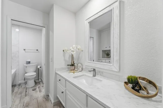 a white toilet and tub sitting next to a bathroom sink