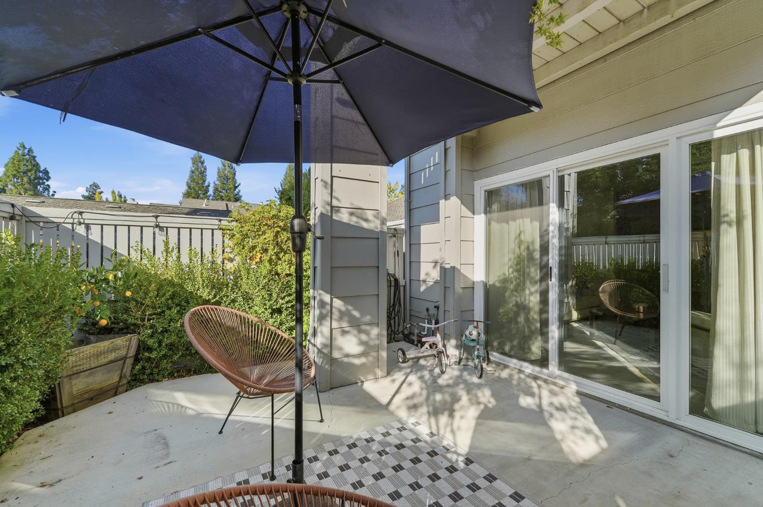 230 West Rumble Road, Unit C Modesto, CA 95350 - Photo 49 of 54 a patio with a table and chairs under an umbrella