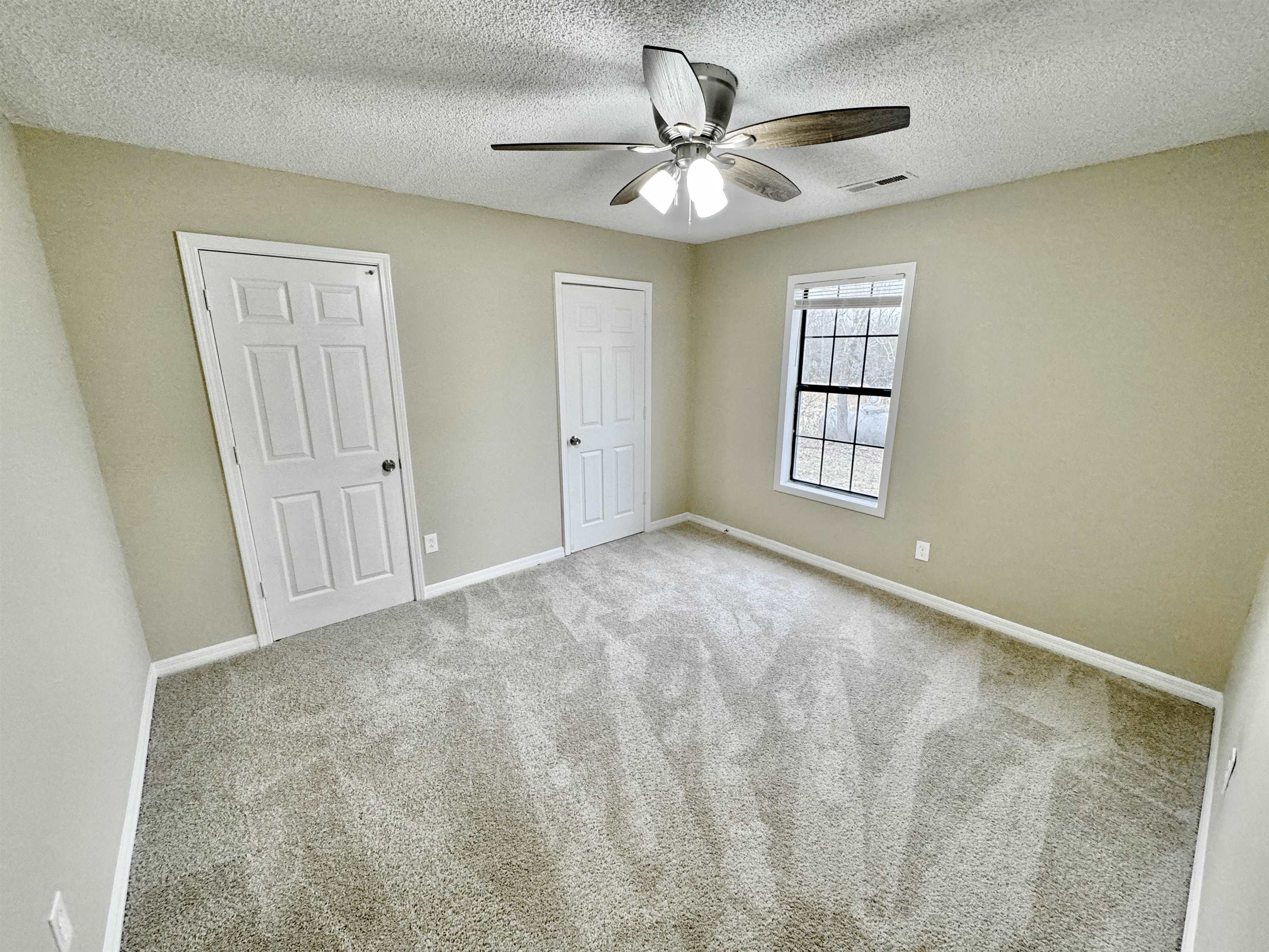 6889 Fulton Road Brownsville, TN 38012 - Photo 15 of 40 Unfurnished bedroom featuring ceiling fan, light colored carpet, and a textured ceiling