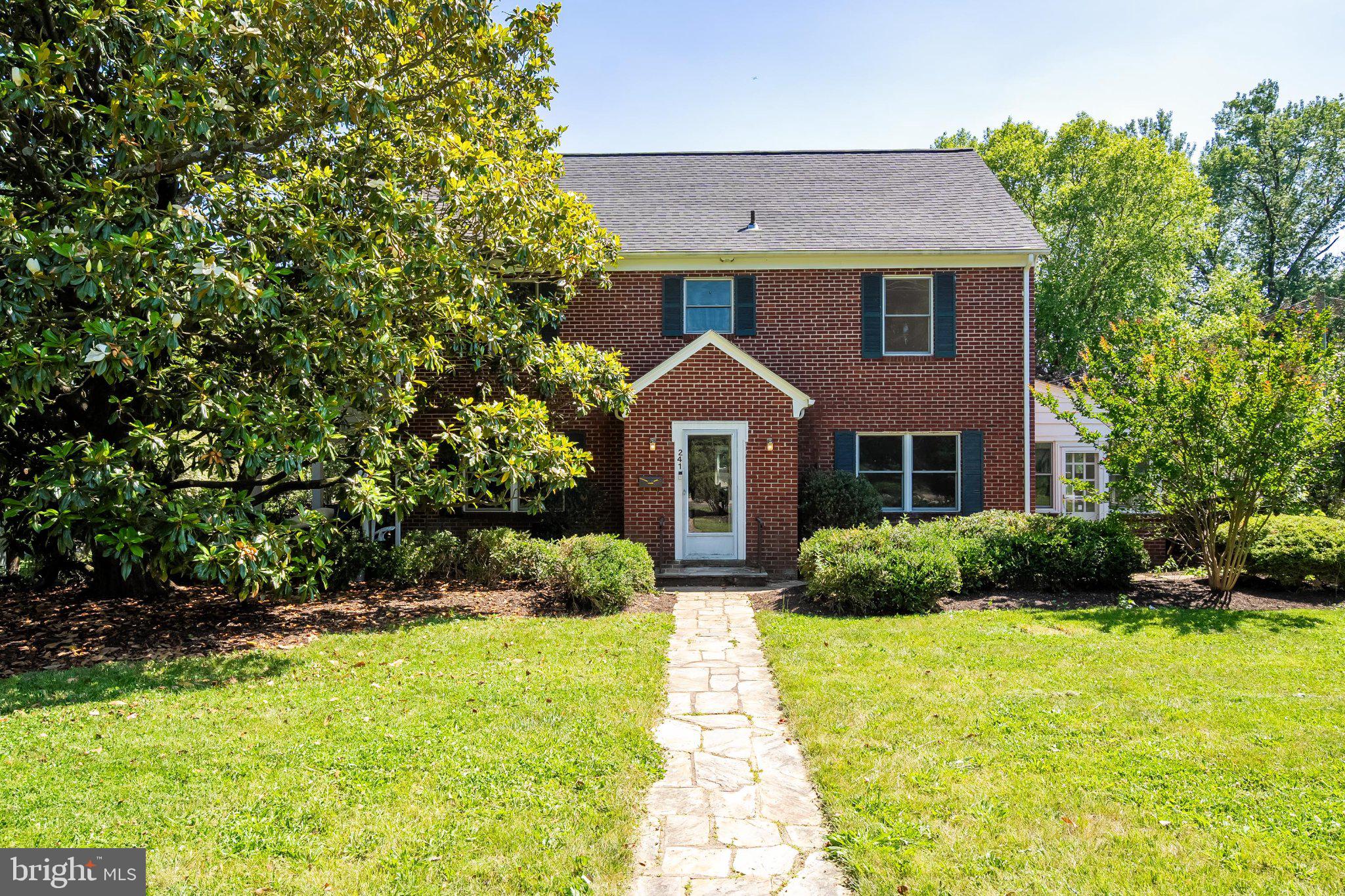 241 Edwards Ferry Road Northeast Leesburg, VA 20176 - Photo 2 of 27 Charming brick home with lush greenery.