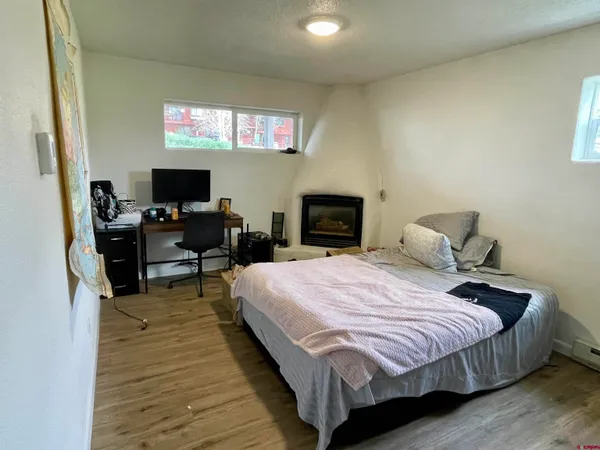 a bedroom with bed and wooden floor