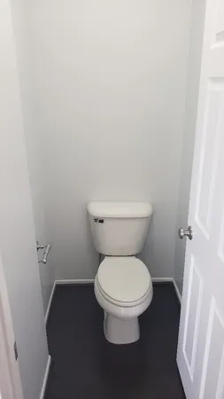 a white toilet sitting next to a shower