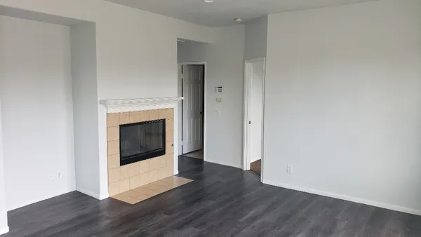 a view of a livingroom with wooden floor and white walls