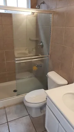 a white toilet sitting next to a bath tub and a shower