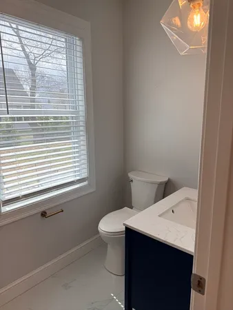 a bathroom with a sink a toilet and a window