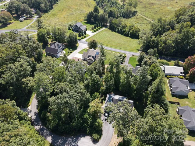 an aerial view of a house with a yard and lake view