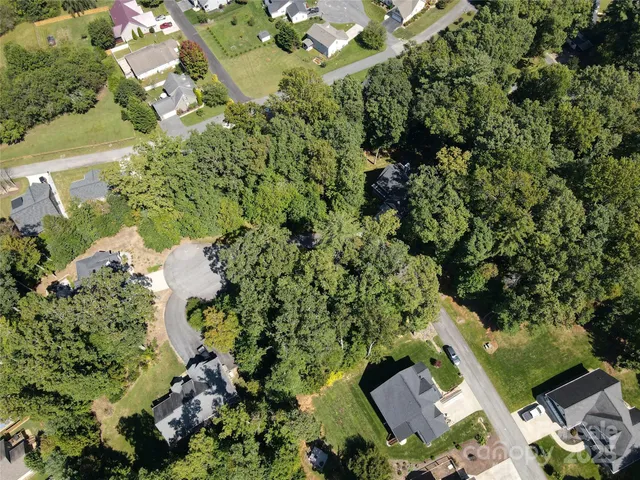 an aerial view of a house with a yard and greenery