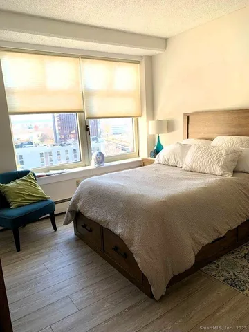 a bedroom with a bed and a large window