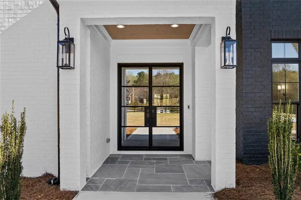 a view of an entryway with wooden floor fireplace and a chandelier