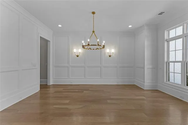 a large kitchen with kitchen island a stove a sink a center island and wooden floor