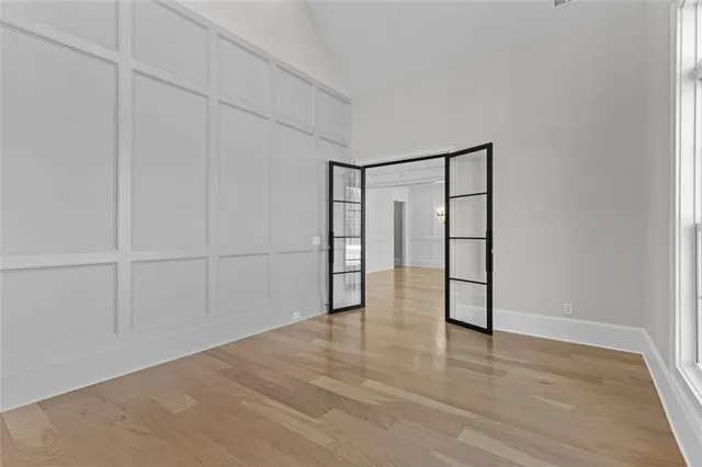 a view of an empty room with a window and wooden floor