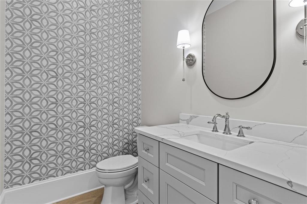 2355 Luke Edwards Road Dacula, GA 30019 - Photo 59 of 115 a bathroom with a granite countertop toilet sink and mirror
