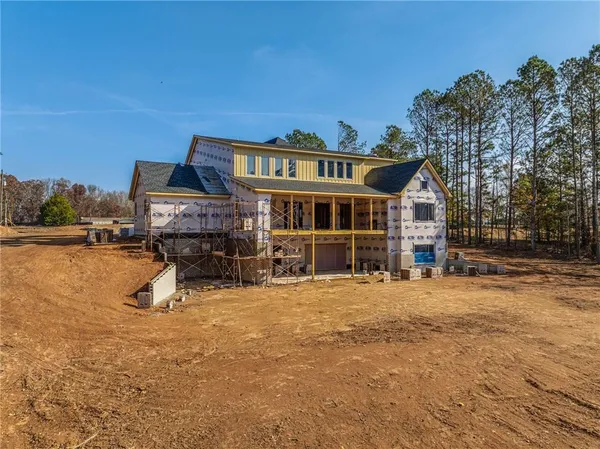 an aerial view of a house with a yard and lake view