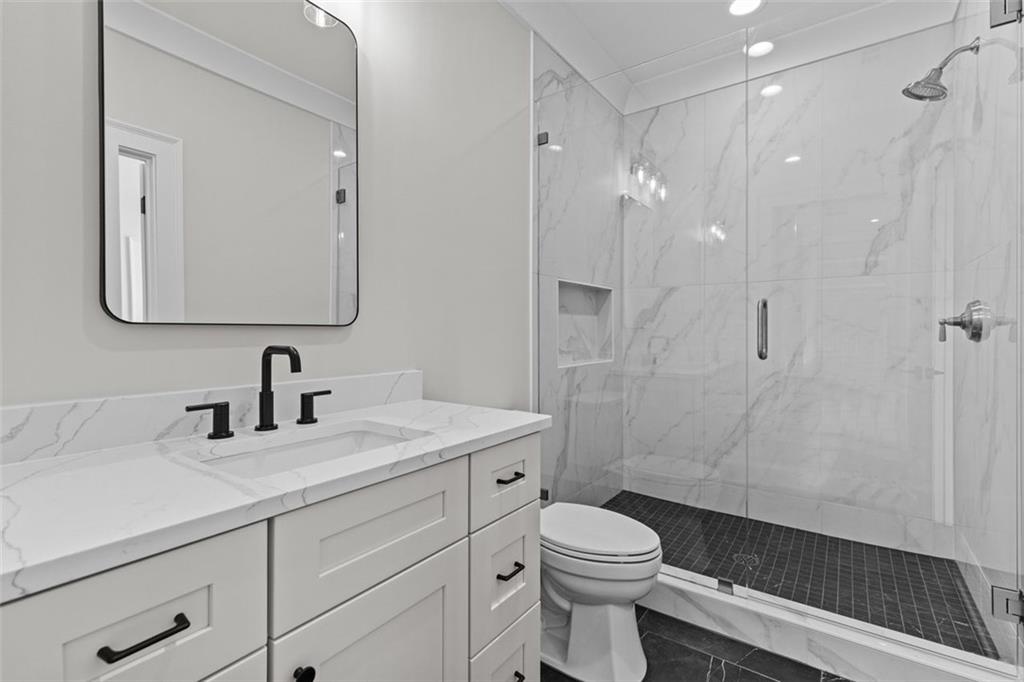 2355 Luke Edwards Road Dacula, GA 30019 - Photo 66 of 115 a bathroom with a sink a toilet a shower and a mirror