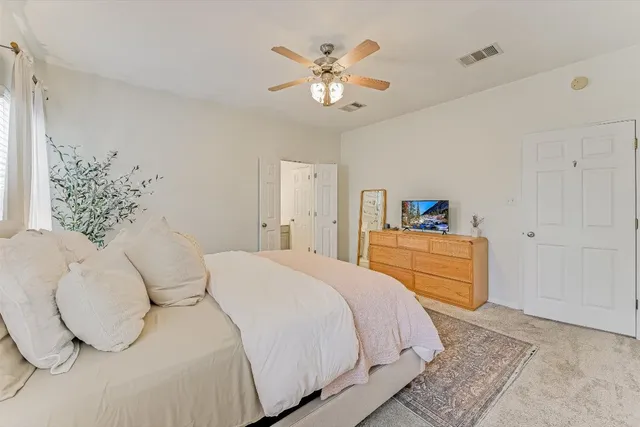 a bedroom with a large bed and a chandelier