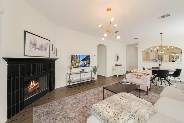 a living room with furniture a fireplace and a table