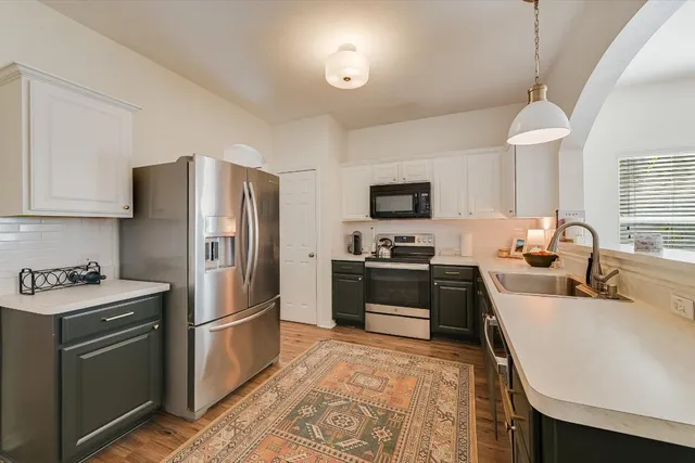 a kitchen with a refrigerator sink and wooden cabinets