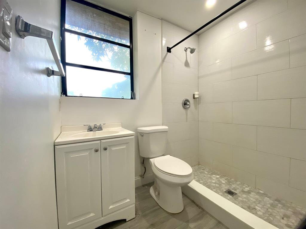 14131 Northwest 3rd Avenue, Unit D Miami, FL 33168 - Photo 7 of 8 a bathroom with a sink a toilet and shower