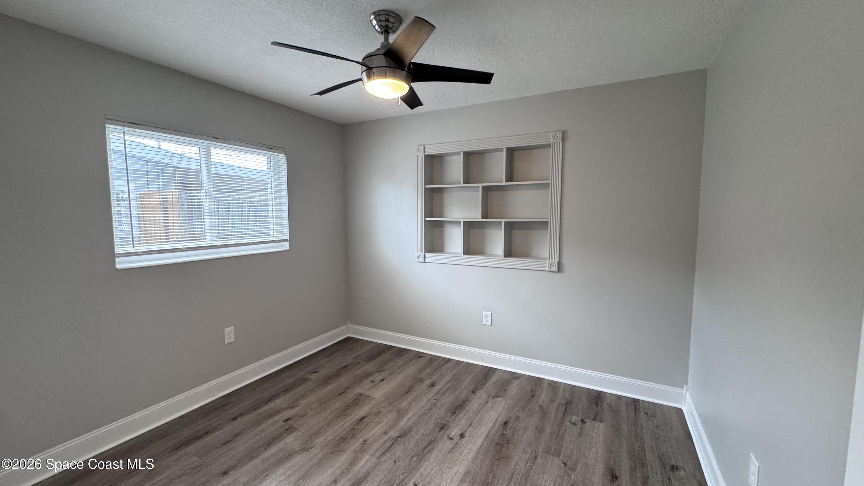 2137 Laden Road Melbourne, FL 32935 - Photo 14 of 23 a view of empty room with wooden floor and fan