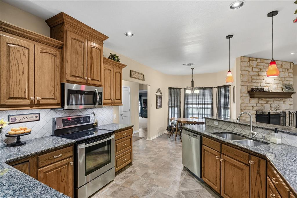 9111 County Road 313 Terrell, TX 75161 - Photo 18 of 40 a kitchen with stainless steel appliances granite countertop a stove a sink and a microwave