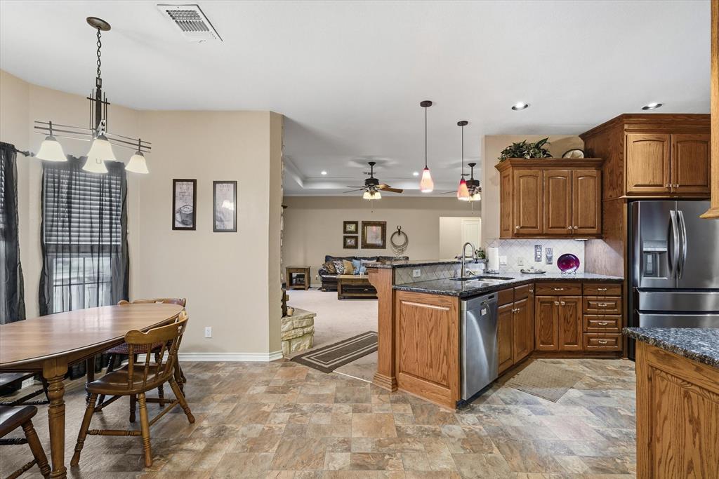 9111 County Road 313 Terrell, TX 75161 - Photo 19 of 40 a kitchen with stainless steel appliances granite countertop a stove top oven a sink dishwasher and a refrigerator