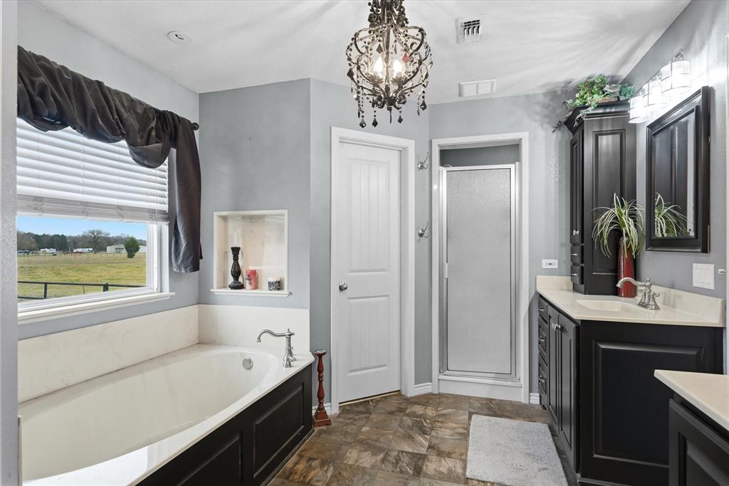 9111 County Road 313 Terrell, TX 75161 - Photo 26 of 40 a spacious bathroom with a sink a large mirror and a bathtub