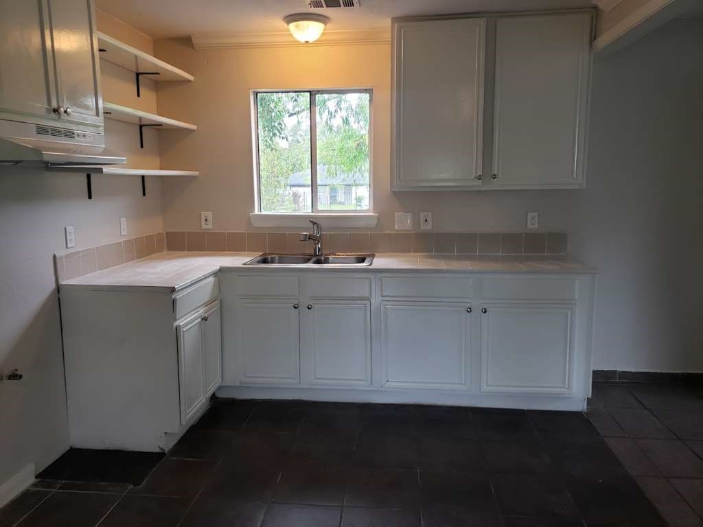 3418 Memel Street Houston, TX 77026 - Photo 10 of 19 a kitchen with a sink dishwasher and cabinets