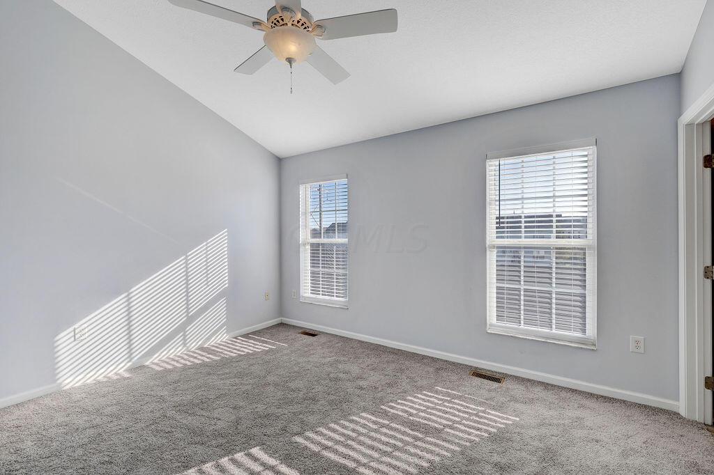 6345 Needletail Road, Unit 24634 Columbus, OH 43230 - Photo 15 of 58 • New gray carpet ~ 2021 • Gray painted walls • Vaulted ceiling • Lighted ceiling fan • 2” blinds