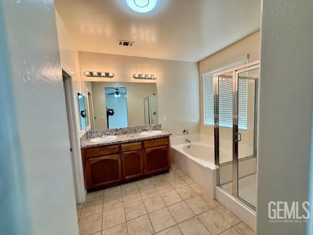 a spacious bathroom with a granite countertop tub sink and mirror