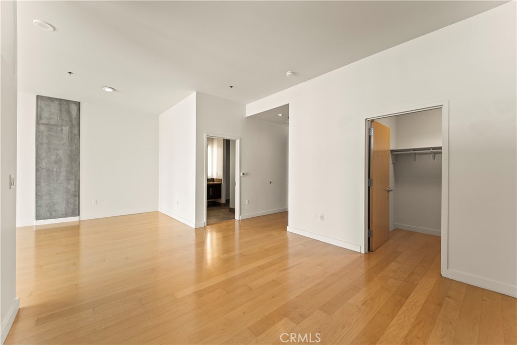 1100 South Hope Street, Unit 1704 Los Angeles, CA 90015 - Photo 4 of 26 a view of an empty room with wooden floor and closet