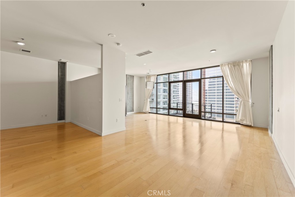 1100 South Hope Street, Unit 1704 Los Angeles, CA 90015 - Photo 6 of 26 a view of an empty room with wooden floor and fence