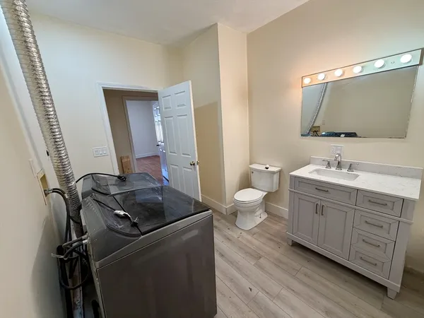 a bathroom with a double vanity sink a mirror and toilet