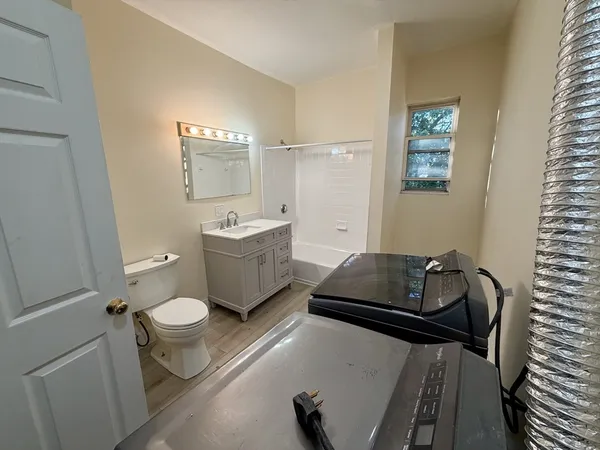 a bathroom with a granite countertop sink mirror vanity and toilet