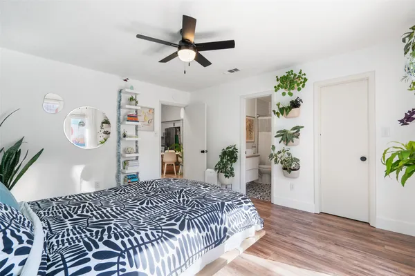 a bedroom with a large bed and a potted plant