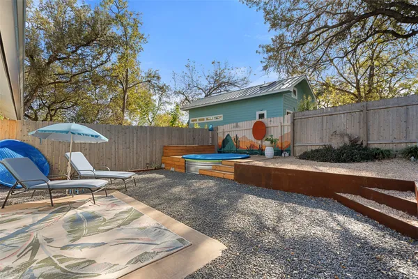 a backyard of a house with table and chairs